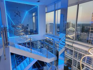 High-rise apartment interior with blue LED lighting and city view.